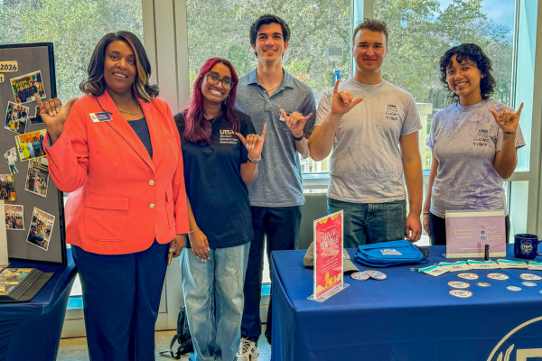 LT with students standing near a decorated table at the Get Involved Fair